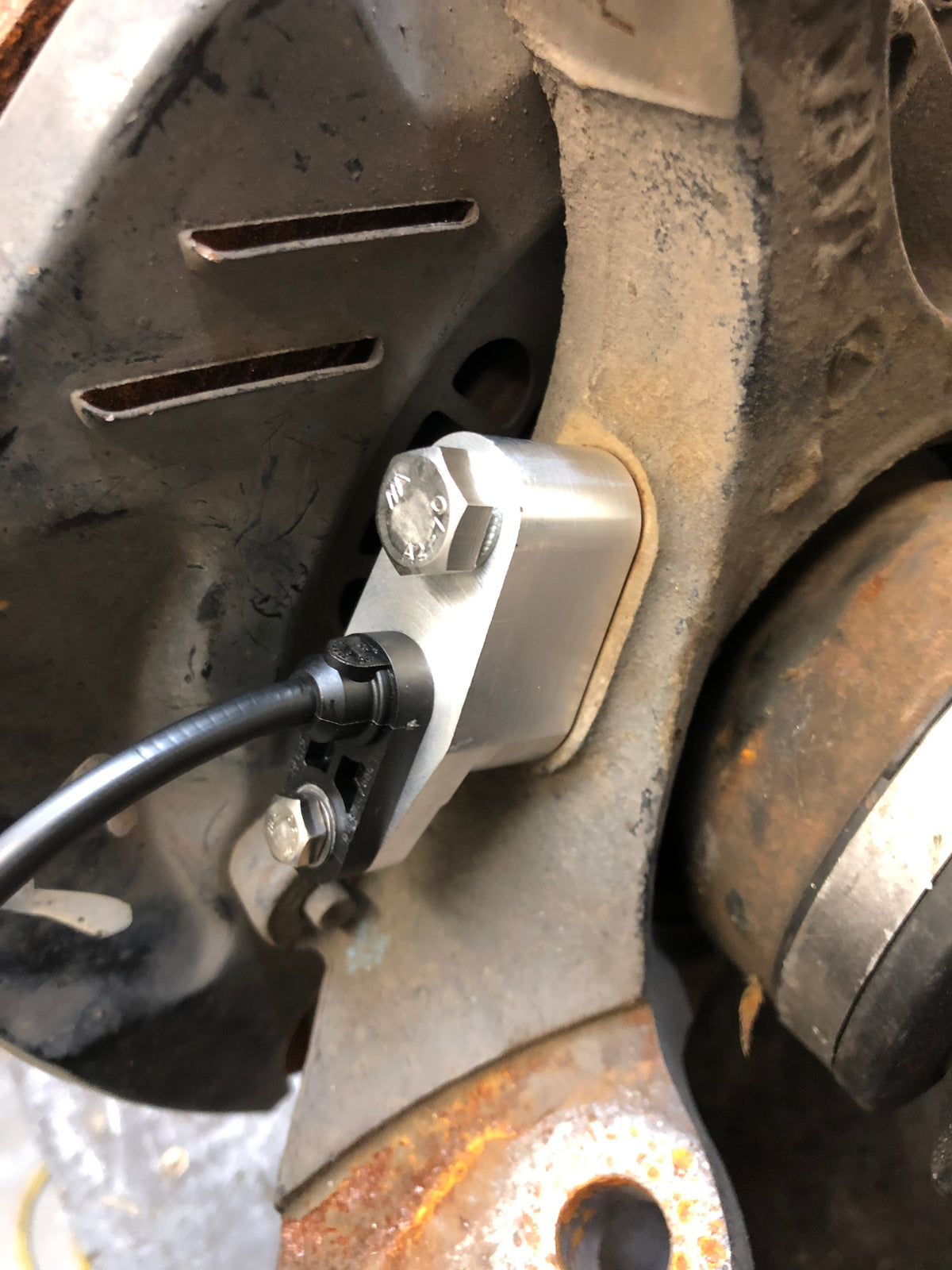 909 wheel speed sensor mount and Bosch DF11 sensor installed at the Subaru WRX GD hub