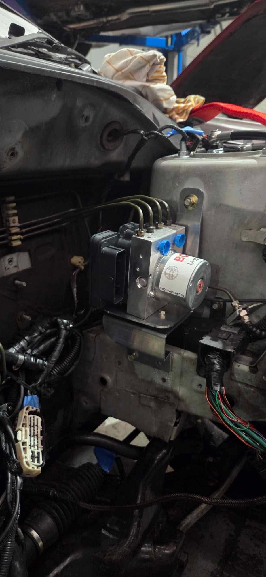 Bosch Motorsport M5 ABS hydraulic unit installed in the engine bay of a Mitsubishi Lancer EVO 7-9