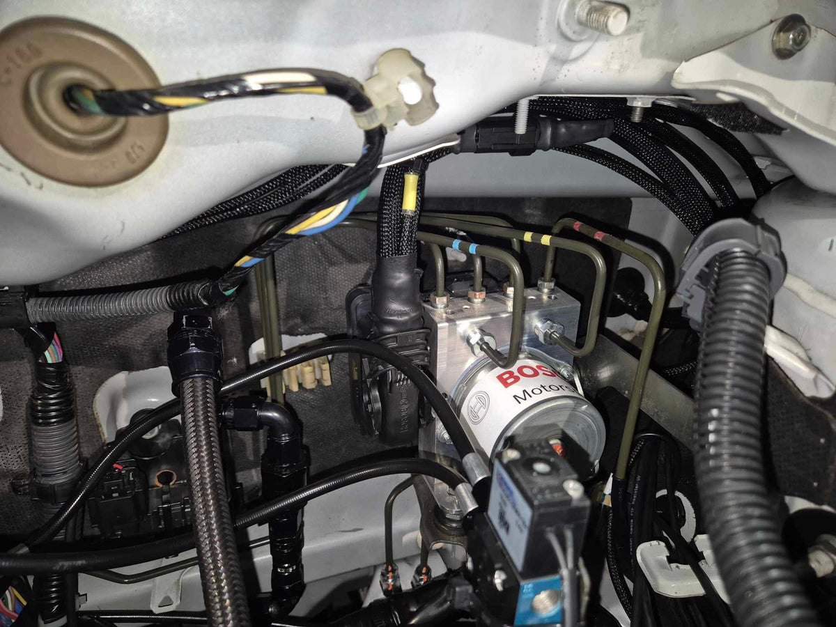 Bosch Motorsport M5 ABS hydraulic unit installed in the factory ABS location on a Mitsubishi Lancer EVO X