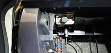 Bosch ABS diagnostic port mounted on a 909 plate in the glovebox corner of a Mitsubishi Lancer EVO X