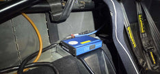 Racelogic VBOX recorder mounted in the Lotus Exige — the 909 parcel-shelf yaw sensor mount is offered with VBOX provision