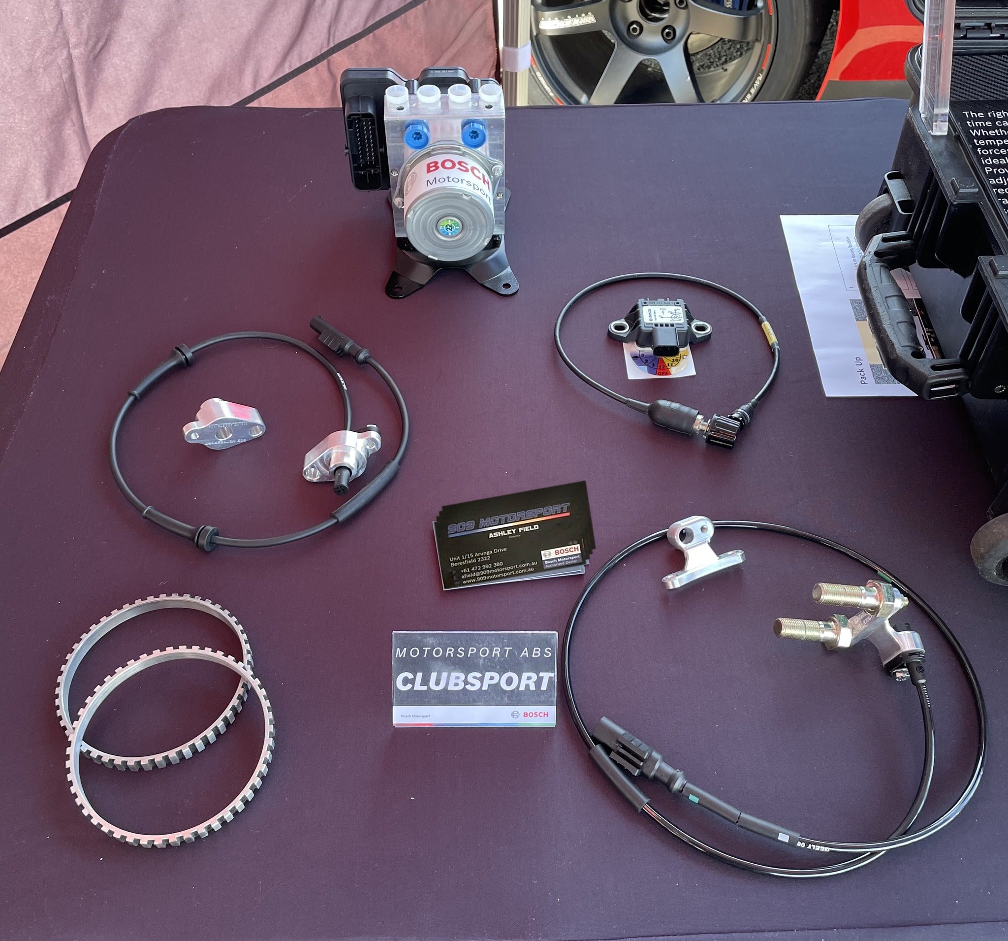 909 Bosch Motorsport Clubsport ABS kit for the Nissan Skyline GT-R laid out on display — hydraulic unit on its mount, wheel speed sensors, machined sensor mounts, tone rings, yaw sensor and map switch