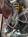 909 front wheel speed sensor mount on a Nissan Skyline GT-R R32 with the Bosch DF11 sensor fitted, sensor cable secured by 909 retainers bolted to the factory clip positions